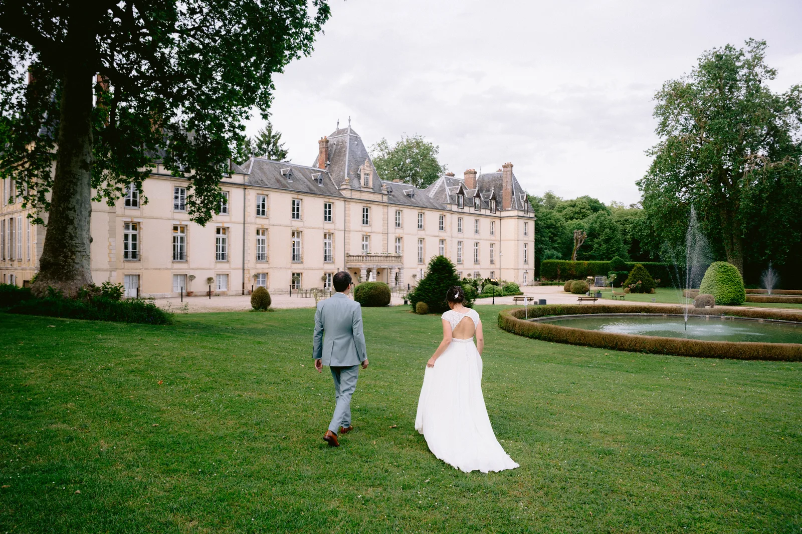 A newlywed couple walking through the grounds of their wedding venue