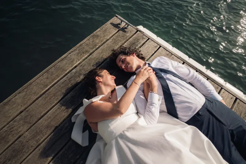 Fanny and Thomas lying on a pontoon beside Lake Annecy