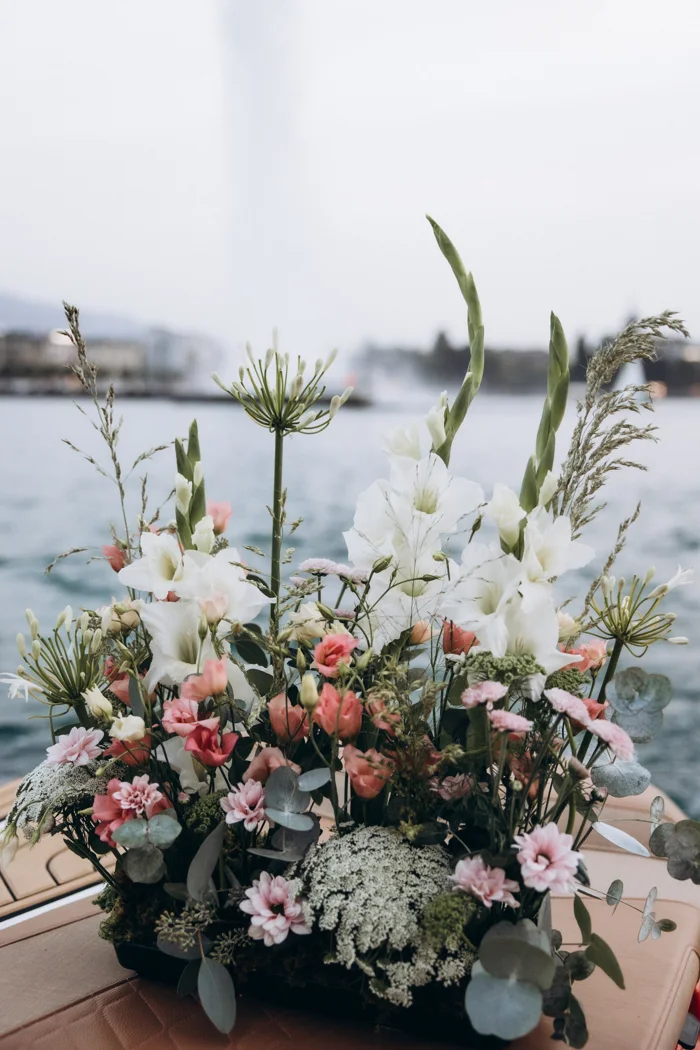 A pale pink and white floral arrangement by Flower Addict on the boat