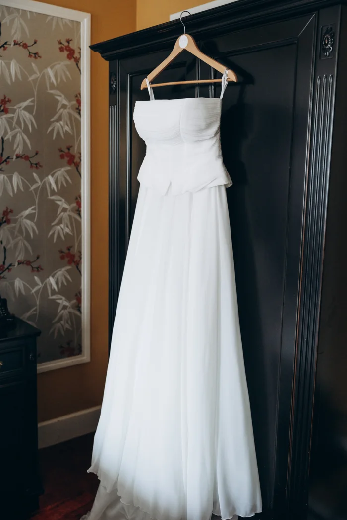 The white dress hanging in the room at Hotel Rotary