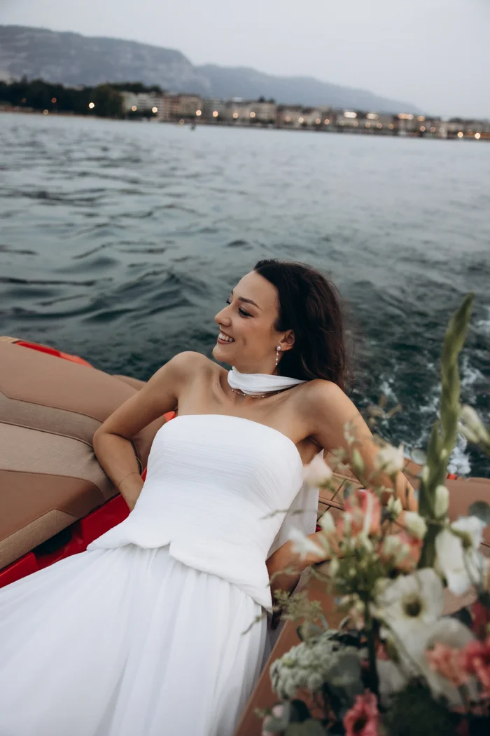 Solenne in a white dress at the bow of the boat