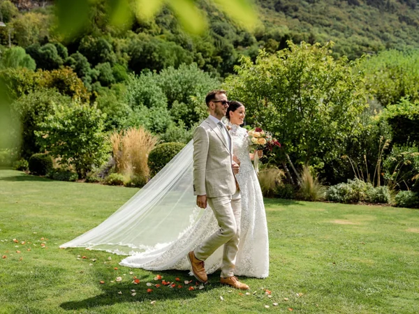 A wedding couple walking through a garden, photographed by Matthieu Philippart